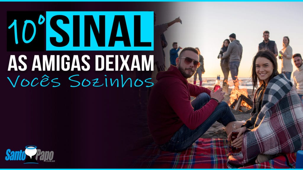 Homem e mulher conversando na praia enquanto grupo de amigos conversa ao fundo